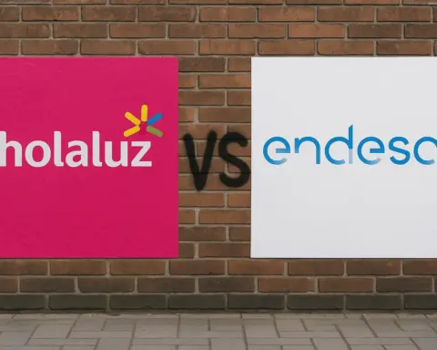 Comparativa visual de Holaluz y Endesa con carteles grandes enfrentados sobre una pared de ladrillo y el texto “vs” en el centro.